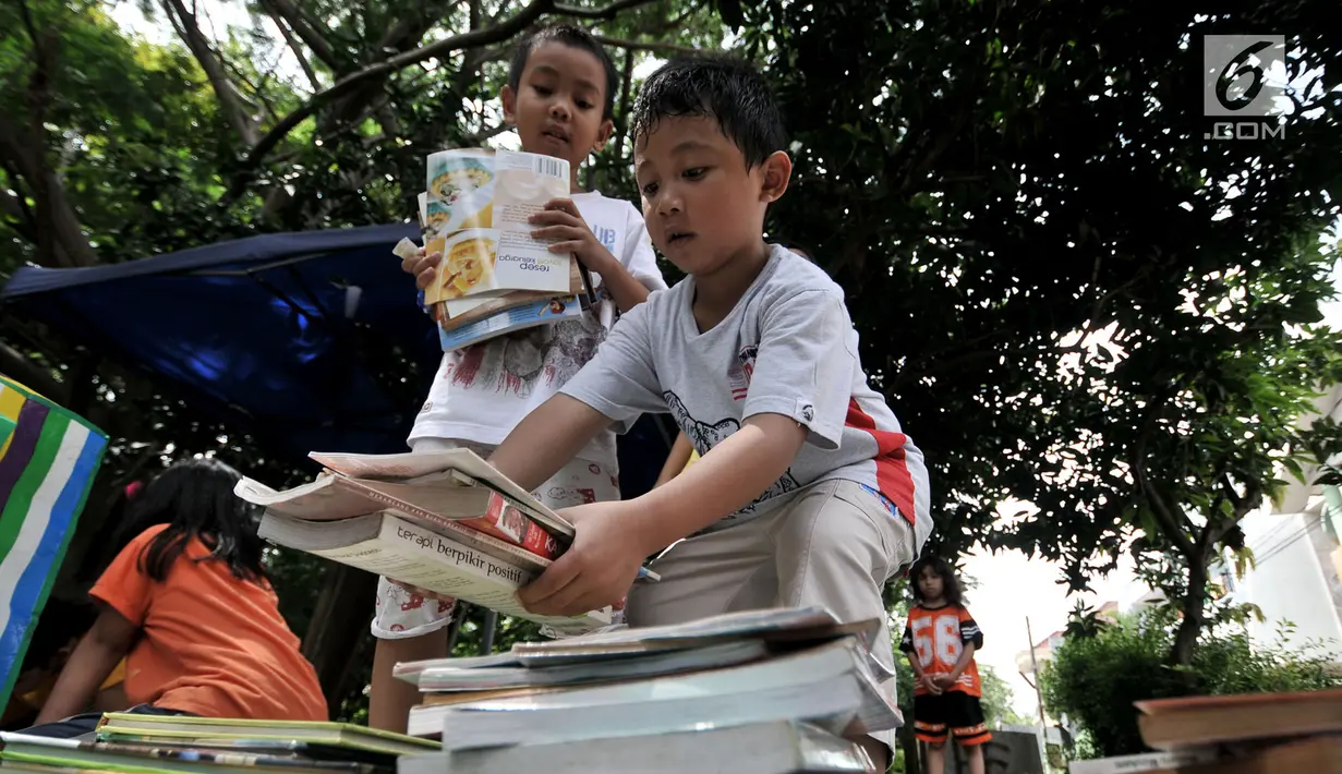 Anak-anak merapikan buku usai mengikuti program Literasi Kejujuran di Taman Bacaan Masyarakat (TBM) Saung Manggar, Pondok Kelapa, Jakarta, Minggu (24/3). (merdeka.com/Iqbal S. Nugroho)