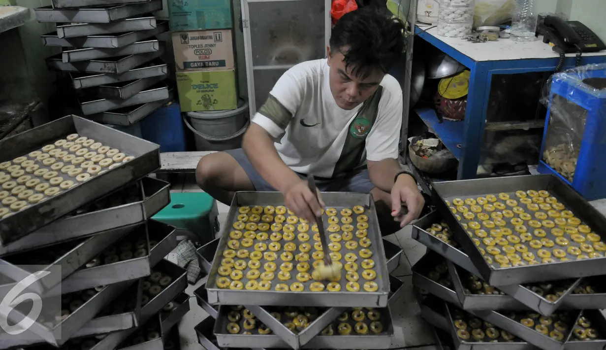 Sebelum dipanggang, kue yang telah dicetak dioleskan mentega terlebih dahulu, Jakarta, Rabu (8/7/2015). Menjelang Hari Raya Idul Fitri permintaan kue kering mengalami lonjakan hingga 100 persen dibandingkan dengan hari biasa. (Liputan6.com/JohanTallo)