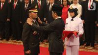 Presiden Joko Widodo atau Jokowi (kanan) memasangkan pangkat jabatan kepada Kapolri Idham Azis saat upacara pelantikan di Istana Negara, Jakarta, Jumat (1/11/2019). Idham Azis dilantik menjadi Kapolri menggantikan Tito Karnavian yang diangkat menjadi Mendagri. (Liputan6.com/Angga Yuniar)