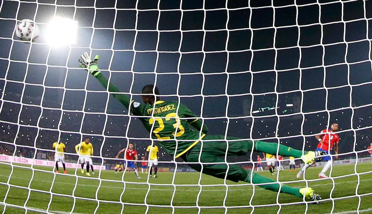 Kiper Ekuador, Alexander Dominguez gagal menghalau tendangan penalti gelandang Chile, Arturo Vidal pada pertandingan pembukaan Copa America 2015 di National Stadium, Santiago, Chile, (11/6/2015). Chile menang 2-0 atas Ekuador. (REUTERS/Ivan Alvarado)