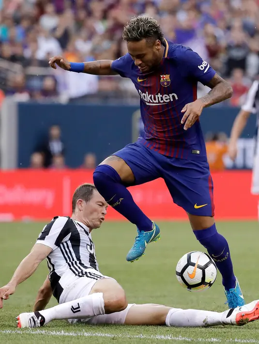 Penyerang Barcelona, Neymar berusaha melewati bek Juventus Stephan Lichtsteiner saat bertanding pada ICC 2017 di Stadion MetLife di East Rutherford, N.J. (22/7). Barcelona menang atas Juventus dengan skor 2-1. (AP Photo / Julio Cortez)