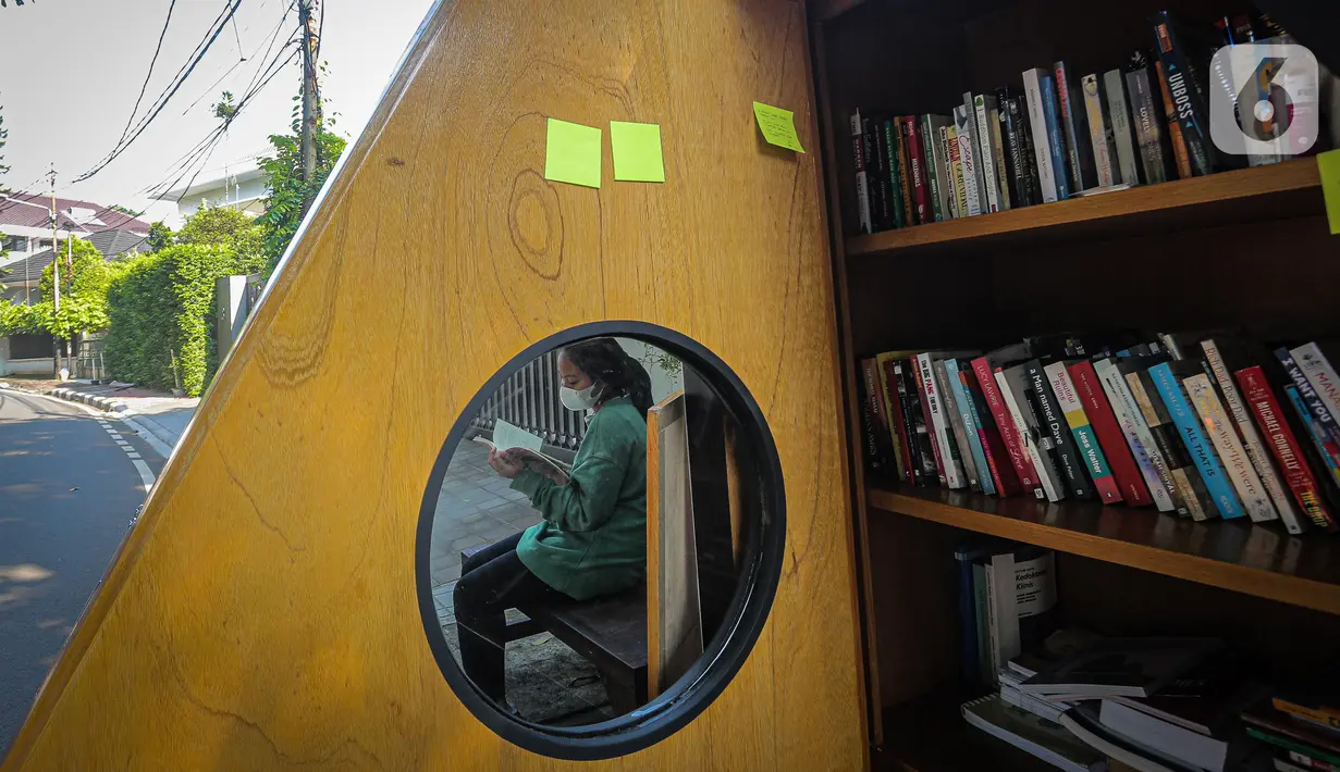 Warga membaca buku dekat perpustakaan bersama Bookhive Jakarta di kawasan Taman Situ Lembang, Jakarta, Selasa (27/4/2021). Pemkot Jakarta Pusat berkolaborasi dengan Bookhive Jakarta memfasilitasi warga untuk bisa meminjam buku gratis atau menyumbang sukarela. (Liputan6.com/Faizal Fanani)