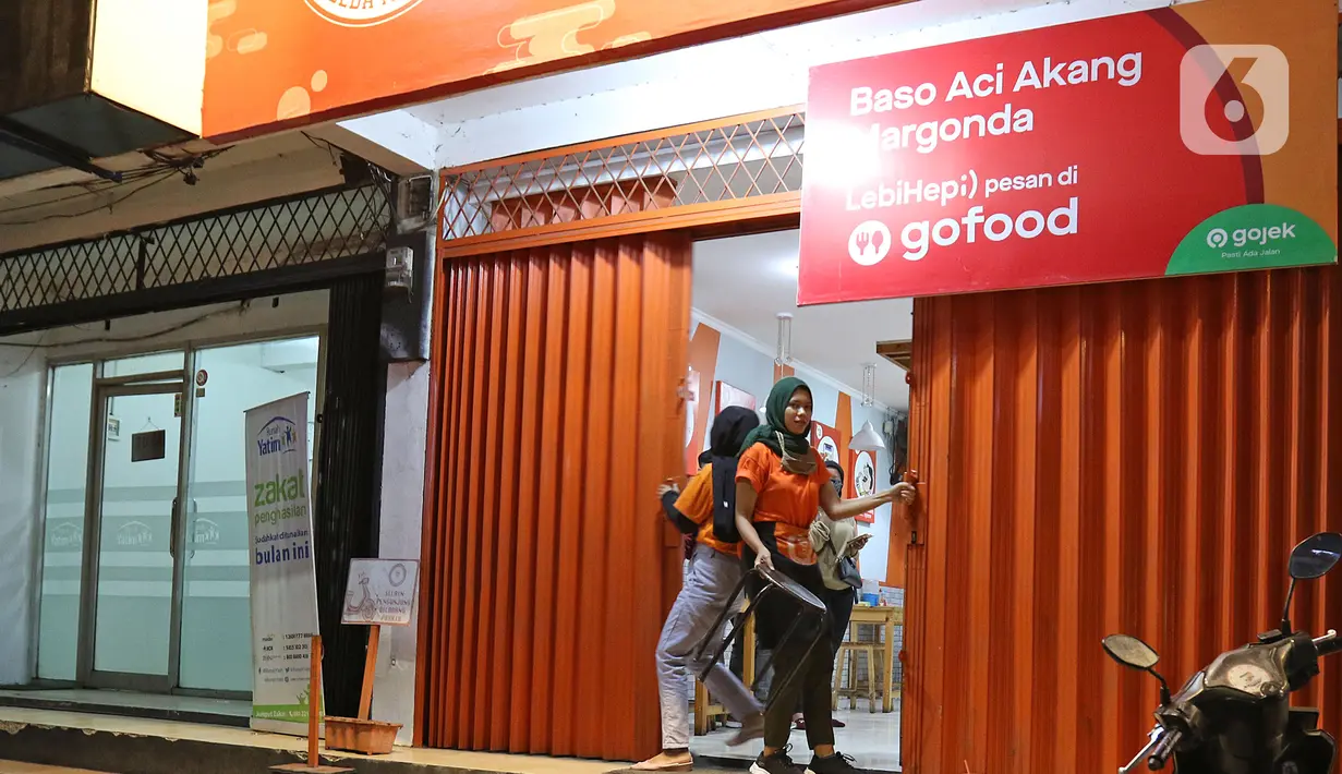 Pekerja menutup toko di  kawasan Margonda, Depok, Jawa Barat, Senin (31/8/2020). Pemkot Depok, Jawa Barat, mulai menerapkan aturan jam malam yang membatasi kegiatan masyarakat di luar rumah untuk menekan risiko penularan Covid-19. (Liputan6.com/Herman Zakharia)