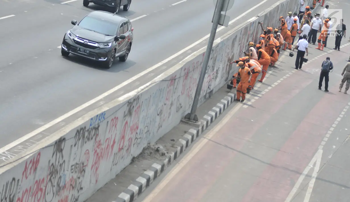 Petugas PPSU mengecat coretan yang mengotori tembok di kawasan Gedung DPR, Jakarta, Rabu (25/9/2019). Demonstrasi mahasiswa yang berujung ricuh yang berujung kerusuhan tersebut menyebabkan fasilitas umum rusak dan penuh coretan yang dibuat oleh pendemo. (merdeka.com/Iqbal S Nugroho)