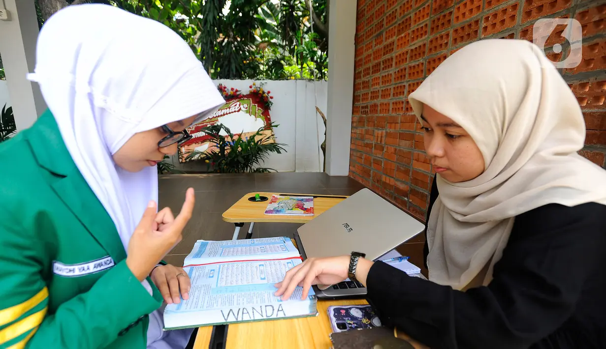 Guru mengajari santriwati penyandang tuna rungu menghafal Al-Qur'an di Pesantren Tahfiz Difabel di Jalan Manunggal Jaya, Lebak Bulus, Jakarta Selatan, Senin (24/10/2022). Pondok Pesantren yang merupakan salah satu program untuk disabilitas dan diinisiasi oleh Baznas (Bazis) Provinsi DKI Jakarta diperuntukkan untuk tuna rungu secara gratis dan baru berjalan 3 bulan saat ini menampung 9 santriwati. (merdeka.com/Arie Basuki)