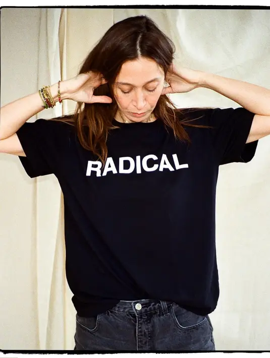 Alana Hadid mengenakan kaus lengan pendek berwarna hitam bertuliskan RADICAL. [Foto: Instagram/lanzybear]