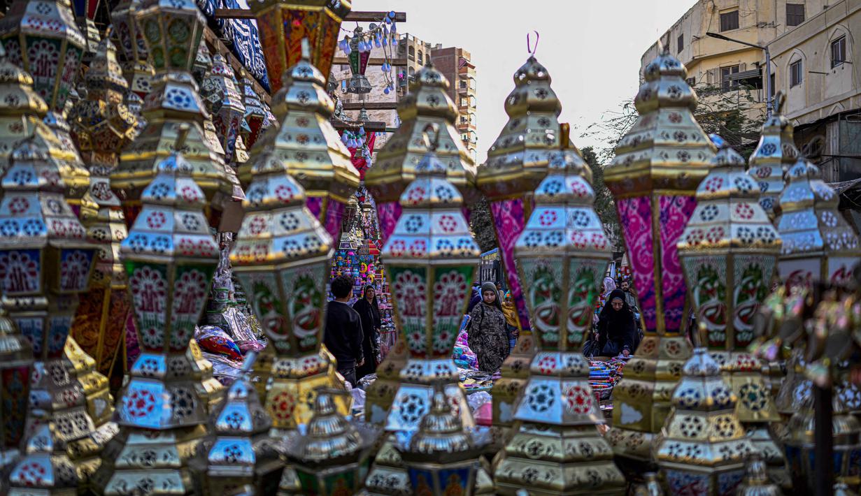 Sejumlah jalan utama dan rumah-rumah dihiasi dengan lentera warna-warni yang menciptakan suasana syahdu pada malam hari. Tampak dalam foto, warga Mesir mencari lampion tradisional, yang dikenal secara lokal sebagai 'Fanous Ramadan', di pusat Kairo pada Kamis 12 Februari 2026. (Khaled DESOUKI/AFP)