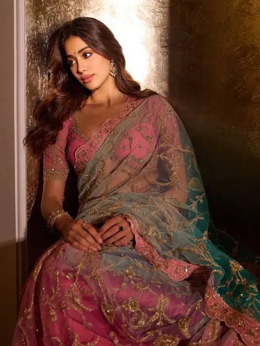Jhanvi Kapoor tampil dengan saree pink dengan atasan crop lengan pendek dipadukan selendang transparan dan rok panjang dihiasi bordiran emas. [@janhvikapoor]