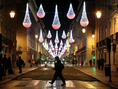 Sejumlah warga yang mengenakan masker berjalan di bawah lampu-lampu Natal dan Tahun Baru pada masa pandemi COVID-19 di Kota Lisbon, Portugal, 17 Desember 2020. Portugal yang memiliki populasi lebih dari 10 juta telah mencatat sebanyak 362.616 kasus COVID-19 dan 5.902 kematian. (Xinhua/Pedro Fiuza)