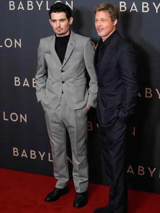 Sutradara Damien Chazelle (kiri) dan aktor Brad Pitt berpose untuk fotografer setibanya pada acara premiere film Babylon di Paris, Prancis, 14 Januari 2023. Brad Pitt melengkapi penampilannya dengan gelang putih dan melengkapi penampilannya dengan sepasang sepatu hitam. (AP Photo/Michel Euler)