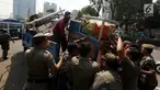Petugas Satpol PP mengangkut gerobak milik pedagang buah keliling saat merazia pedagang kaki lima di kawasan Karet, Jakarta, Senin (17/7). Razia itu untuk membuat jera pedagang yang nakal dan tetap nekat berjualan di bahu jalan. (Liputan6.com/Johan Tallo)