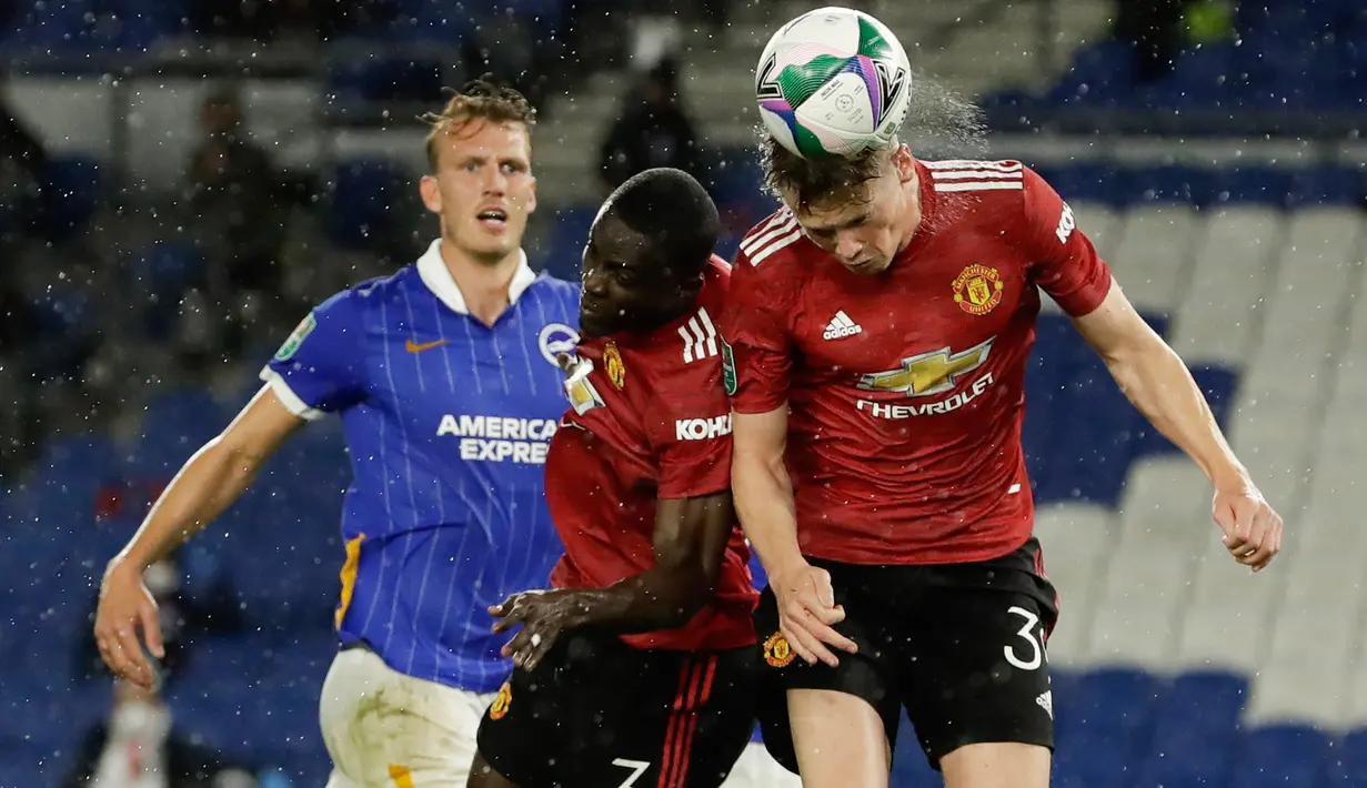 Gelandang Manchester United (MU), Scott McTominay (kanan) menyundul bola untuk mencetak gol ke gawang Brighton Albion dalam lanjutan Piala Liga di Stadion Falmer, Kamis (1/10/2020) dinihari WIB. MU menang 3-0 atas Brighton Albion. (Matt Dunham/Pool via AP)