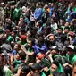 Ratusan suporter klub Persebaya duduk antri mengambil makanan di kawasan GOR Padjajaran, Bandung, Sabtu (7/1). Seiring pelaksanaan kongres PSSI 2017, pendukung Persebaya Surabaya berkumpul di GOR Padjajaran, Bandung. (Liputan6.com/Helmi Fithriansyah)