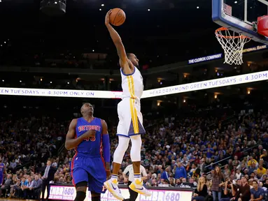 Pebasket Golden State Warriors Andre Iguodala melakukan Dunk saat dibayangi pebasket Detroit Pistons Anthony Tolliver di ORACLE Arena, California, Senin (9/11/2015). Warriors menang 109-95. (Getty Images/AFP/Ezra Shaw)