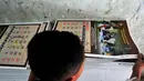 Seorang pekerja merapikan hasil pencetakan kalender 2015 di tempat percetakan, Senen, Jakarta, Senin (1/12/2014). (Liputan6.com/Johan Tallo)