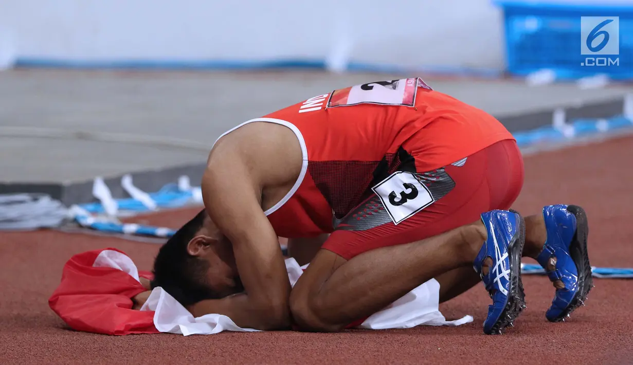 Atlet para-atletik Indonesia, Sapto Yogo Purnomo bersujud syukur usai laga lari nomor 100 meter T37 pria yang  digelar di Stadion GBK, Jakarta, Selasa (9/10). Ini menjadi medali emas kedua Sapto di Asian Para Games 2018. (Liputan6.com/Helmi Fithriansyah)