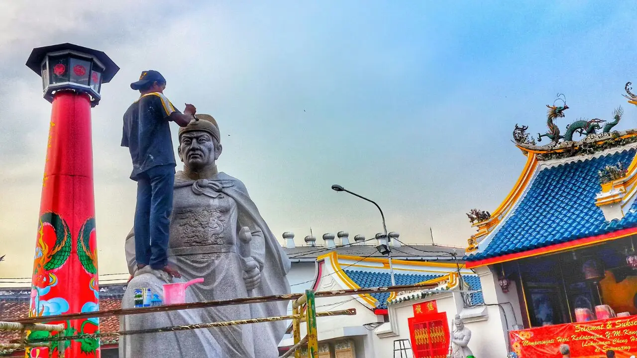 Seorang pekerja sedang membersihkan dan merapikan patung Laksamana Cheng Hoo di Kelenteng Tay Kak Sie. (foto : Liputan6.com/vega/edhie prayitno ige)