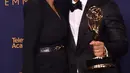 Chrissy Teigen mencium John Legend selama Creative Arts Emmy 2018 di Microsoft Theater di Los Angeles, California, AS (9/9). Penghargaan ini untuk artis yang telah memenangkan di Emmy, Grammy, Oscar, dan Tonys. (AFP Photo/Alberto E. Rodriguez)