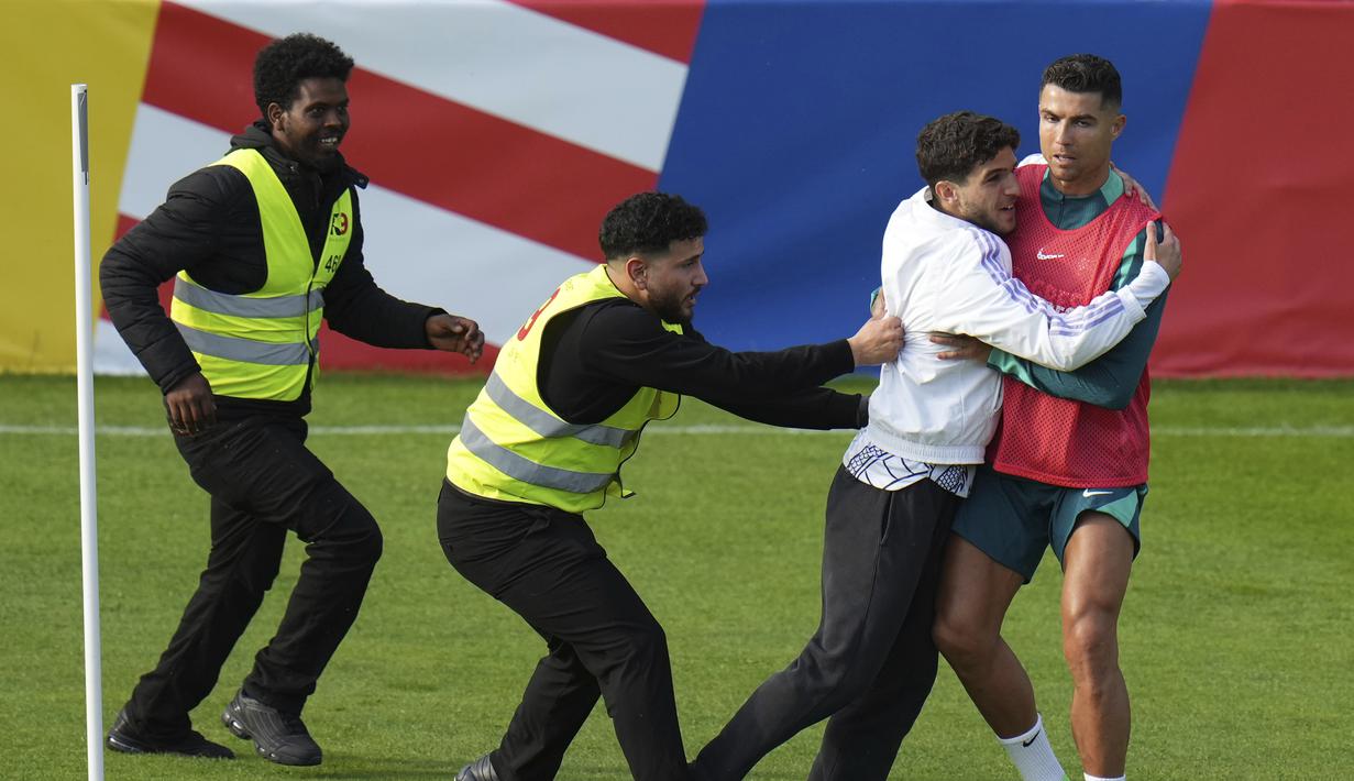 Seorang penggemar menempel pada penyerang Portugal Cristiano Ronaldo selama sesi latihan di Gutersloh, Jerman, Jumat, 14 Juni 2024. (AP Photo/Hassan Ammar)