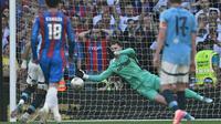 Kiper Crystal Palace, Dean Henderson menghalau bola tendangan penalti pemain Manchester City, Omar Marmoush dalam laga final Piala FA 2024/2025 di Stadion Wembley, London, Inggris, Sabtu (17/05/2025) waktu setempat. (AFP/Adrian Dennis)
