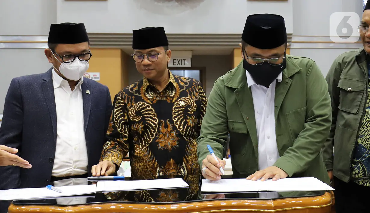 Menteri Agama Yaqut Cholil Qoumas (kanan) bersama Ketua Komisi VIII DPR Yandri Susanto menandatangi dokumen Penetapan Biaya Penyelenggaraan Ibadah Haji Tahun 1443 H/2022 dalam rapat kerja dengan Komisi VIII DPR di Kompleks Parlemen, Senayan, Jakarta, Rabu (13/4/2022). (Liputan6.com/Angga Yuniar)