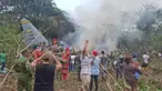 Orang-orang berdiri di sekitar pesawat kargo militer yang jatuh setelah lepas landas dari Puerto Leguizamo, Kolombia, sebuah kotamadya terpencil di provinsi Amazon Putumayo, Senin, 23 Maret 2026. Sebuah pesawat angkut militer milik Angkatan Udara Kolombia jatuh saat lepas landas di wilayah selatan Provinsi Putumayo. (MiPutumayo via AP)