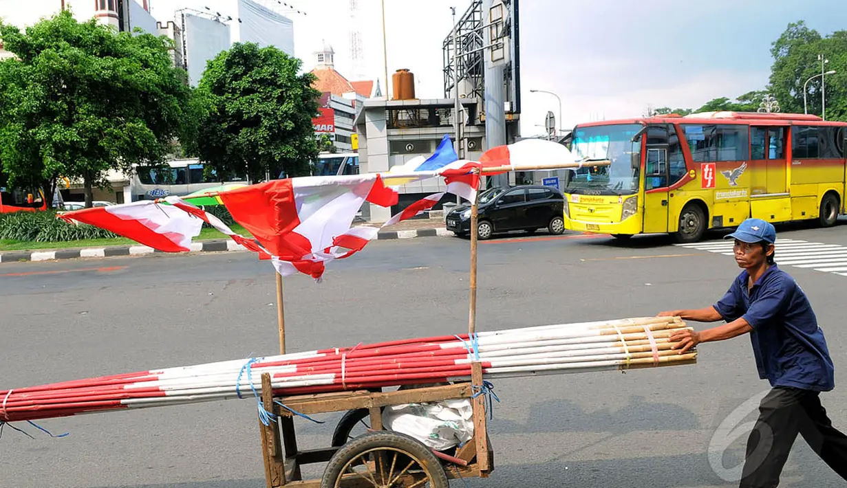 Selain mangkal di tepian jalan, pedagang bendera itu ada pula yang menjajakan dengan cara keliling mendorong gerobak, Minggu (3/8/14). (Liputan6.com/Faisal R Syam)