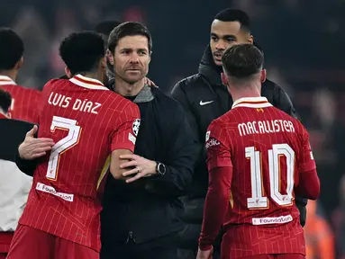 Pelatih Bayer Leverkusen, Xabi Alonso (tengah) berpelukan dengan pemain Liverpool, Luis Diaz setelah pertandingan lanjutan Liga Champions 2024/2025 yang berlangsung di Anfield, Liverpool, Inggris, Rabu (06/11/2024) dini hari WIB. (AFP/Paul Ellis)