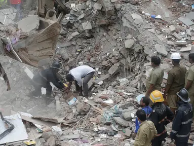 Tim penyelamat mengevakuasi korban akibat runtuhnya gedung lima lantai di Mumbai, India, Selasa (25/7). Sebuah gedung penghunian lima lantai runtuh pada selasa pagi waktu setempat. (AP/Rafiq Maqbool) 