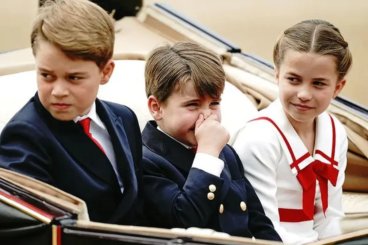 Pangeran Louis menutup hidungnya saat duduk diapit kedua kakaknya, Pangeran George dan Putri Charlotte saat menjadi bagian dalam arak-arakan di acara Trooping the Color 2023. (Twitter/@JohnMarkKarr)