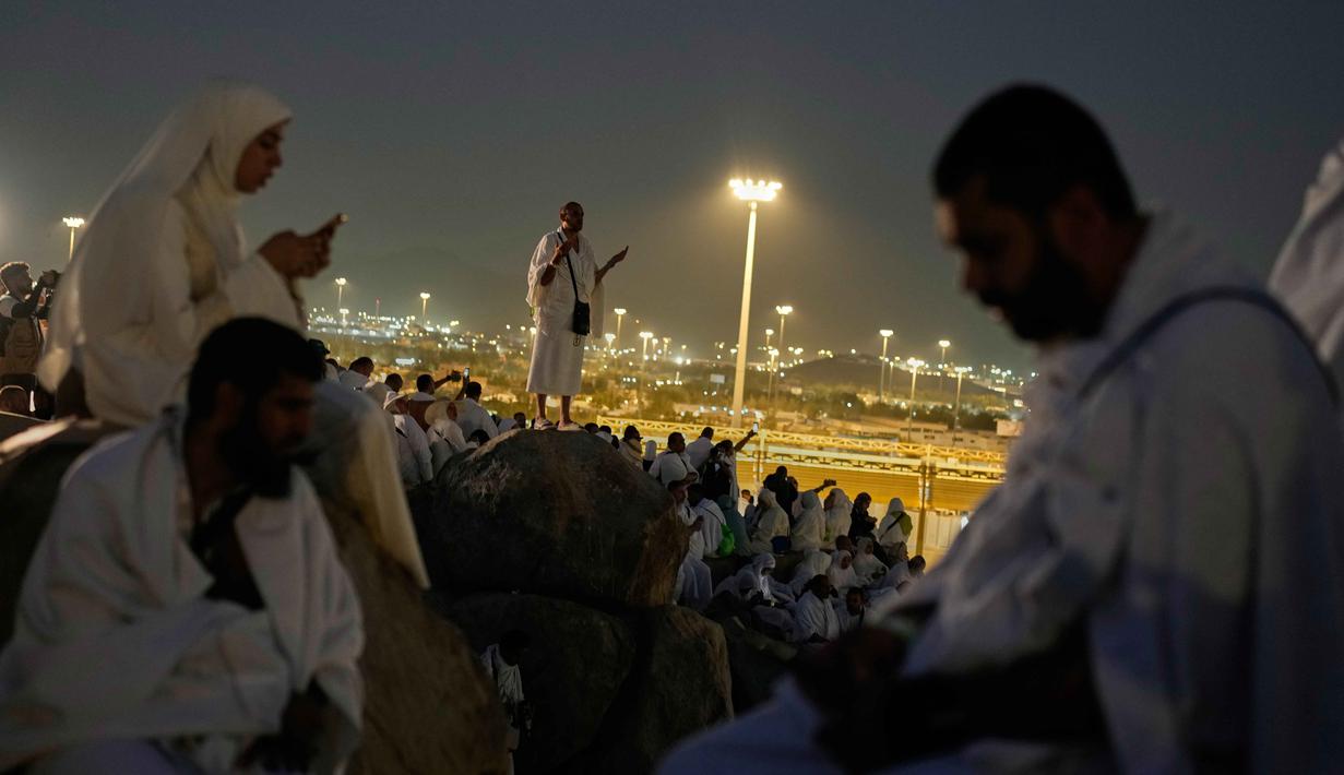 Umat Muslim berdoa di puncak bukit berbatu yang dikenal sebagai Jabal Rahmah atau Gunung Rahmat, di Dataran Arafah, selama ibadah haji tahunan di dekat kota suci Mekah, Arab Saudi, Selasa 26 Mei 2026. (AP Photo/Altaf Qadri)