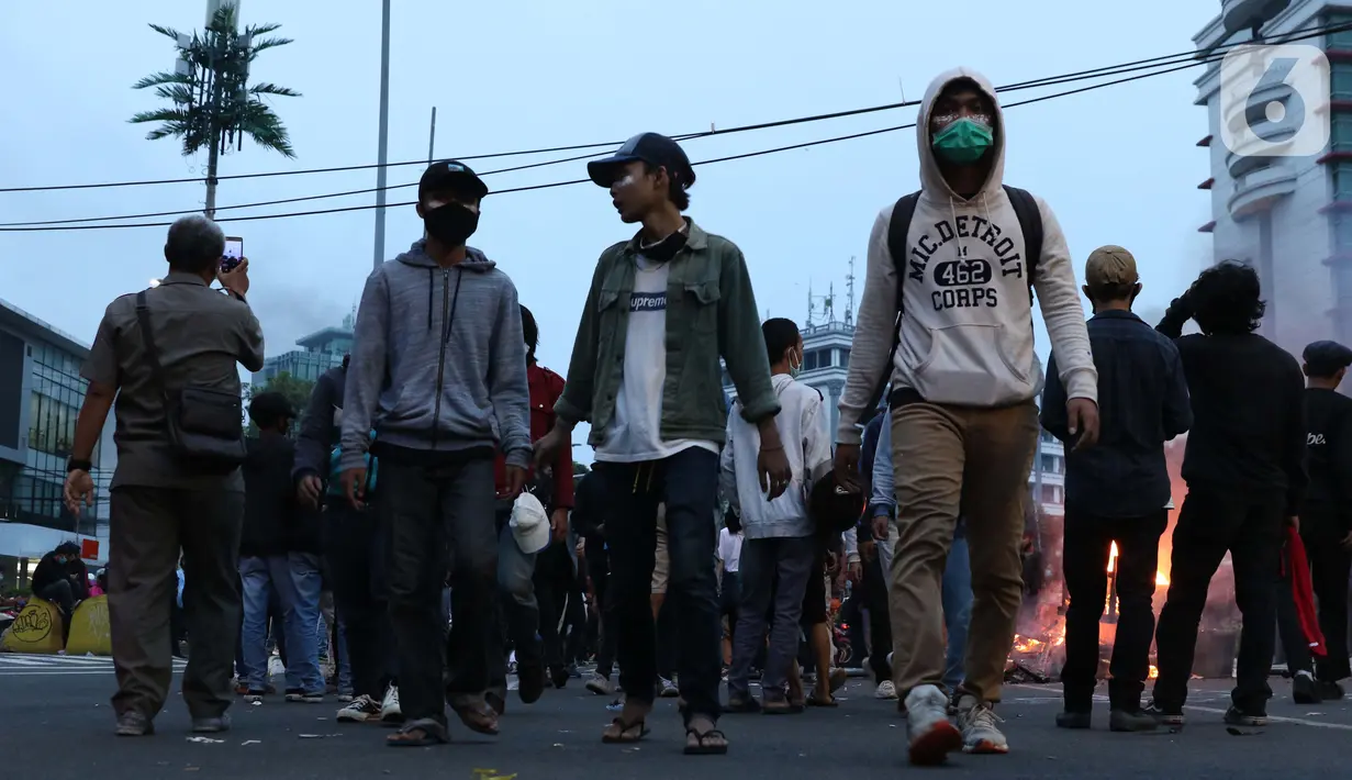 Sekelompok anak muda melintasi kawasan Gondangdia, Jakarta, Kamis (8/10/2020). Massa gabungan berunjuk rasa menentang disahkan Omnibus Law UU Cipta Kerja. (Liputan6.com/Helmi Fithriansyah)
