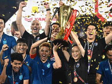 Thailand berhasil menjuarai ajang Piala AFF 2022 setelah mengalahkan Vietnam dengan agregat 3-2 di partai final pada Senin (16/01/2023). Keberhasilan merengkuh gelar back-to-back tersebut tak lepas dari peran sang manajer, Nualphan Lamsam atau akrab disebut Madam Pang (tengah kanan). (AFP/Lillian Suwanrumpha)
