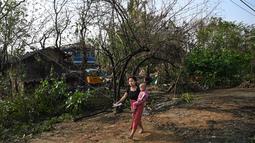 Topan Mocha menerjang daratan Myanmar dan Bangladesh tenggara pada 14 Mei, menumbangkan pepohonan, merobohkan rumah-rumah tipis di kamp-kamp pengungsian Rohingya, dan membawa gelombang badai ke daerah dataran rendah. (Photo by Sai Aung MAIN / AFP)