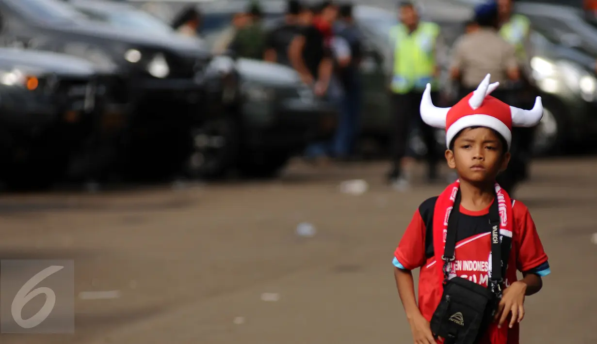 Seorang anak berpakaian ala suporter Semen Padang saat memasuki areal Stadion GBK Jakarta, Minggu (24/1/2016). Semen Padang akan melawan Mitra Kukar dalam laga final Piala Jenderal Sudirman. (Liputan6.com/Helmi Fithriansyah)