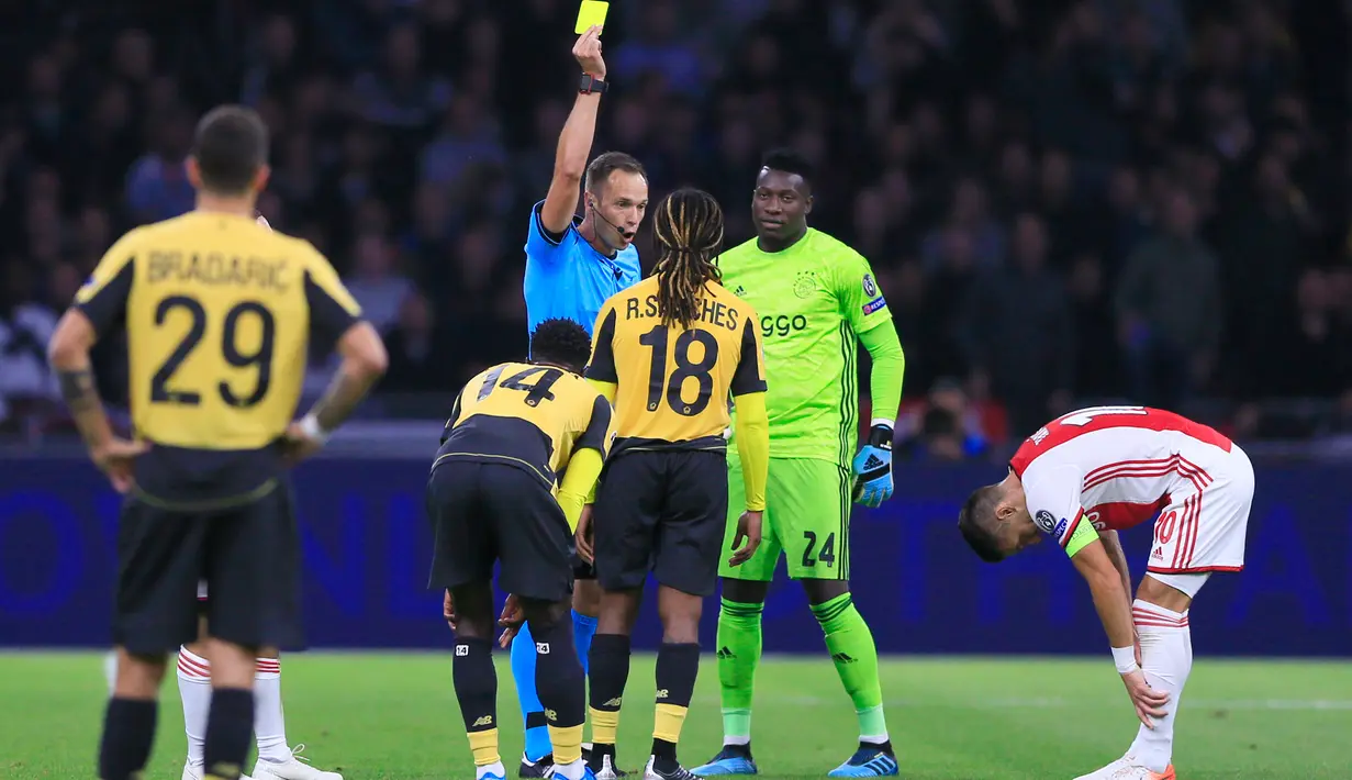 Pemain Lille, Renato Sanches (tengah) mendapat kartu kuning dari wasit usai mendorong pemain Ajax, Dusan Tadic pada laga Grup H Liga Champions di Amsterdam, Belanda, Selasa (17/9/2019). Ajax memuncaki klasemen Grup H Liga Champions usai mengalahkan Lille 3-0. (AP Photo/Peter Dejong)