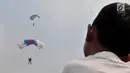 Warga menyaksikan aksi terjun payung saat Festival Damai Millenial Road Safety di Monas, Jakarta, Minggu (23/6/2019). Aksi ini diikuti puluhan penerjun payung dari personel gabungan TNI-Polri. (merdeka.com/Iqbal Nugroho)
