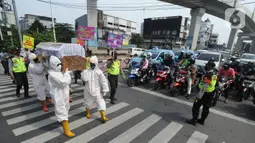 Petugas Gabungan membawa peti mati di hadapan pengendara bermotor di perempatan Fatmawati, Jakarta Selatan, Kamis (3/9/2020). Kegiatan tersebut dalam rangka sosialisasi kewaspadaan dan kesadaran warga ibukota di tengah pandemi corona yang dapat menyebabkan kematian. (merdeka.com/Arie Basuki)