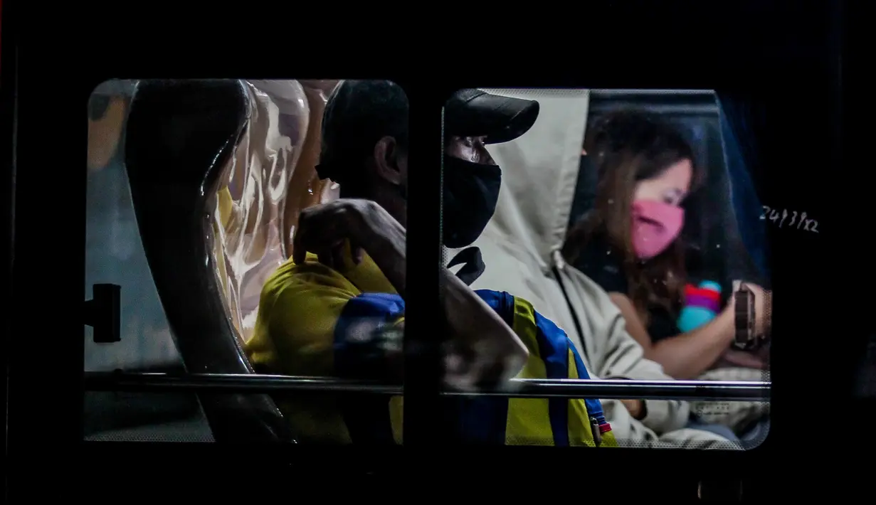 Penumpang mengenakan masker di dalam sebuah bus yang terjebak macet di Manila (3/8/2020). Kemacetan terjadi ketika orang-orang bergegas keluar dari Metro Manila beberapa jam sebelum pemerintah memberlakukan lockdown di kawasan itu akibat lonjakan kasus penyakit Covid-19. (Xinhua/Rouelle Umali)