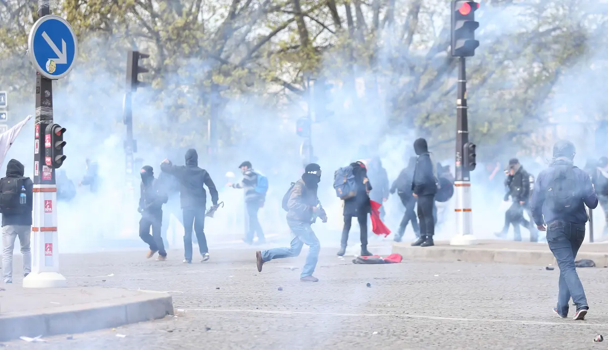 Gas air mata terlihat saat demonstrasi menolak reformasi undang-undang buruh di Paris, Prancis, Kamis (28/4). Bentrokan terjadi saat polisi menembakkan gas air mata kepada demonstran yang melemparinya dengan botol dan bebatuan. (REUTERS/Charles Platiau)  
