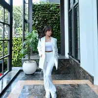 Blazer putih ini melapisi cropped tanktop dan celana putih yang ia kenakan [@fuji_an]
