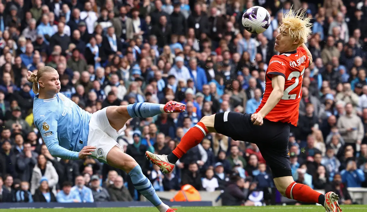 Striker Manchester City, Erling Haaland (kiri) melepaskan tendangan yang membentur bek Luton Town, Daiki Hashioka hingga berbuah gol bunuh diri pada laga pekan ke-33 Premier League 2023/2024 di Etihad Stadium, Manchester, Sabtu (13/4/2024). (AFP/Darren Staples)