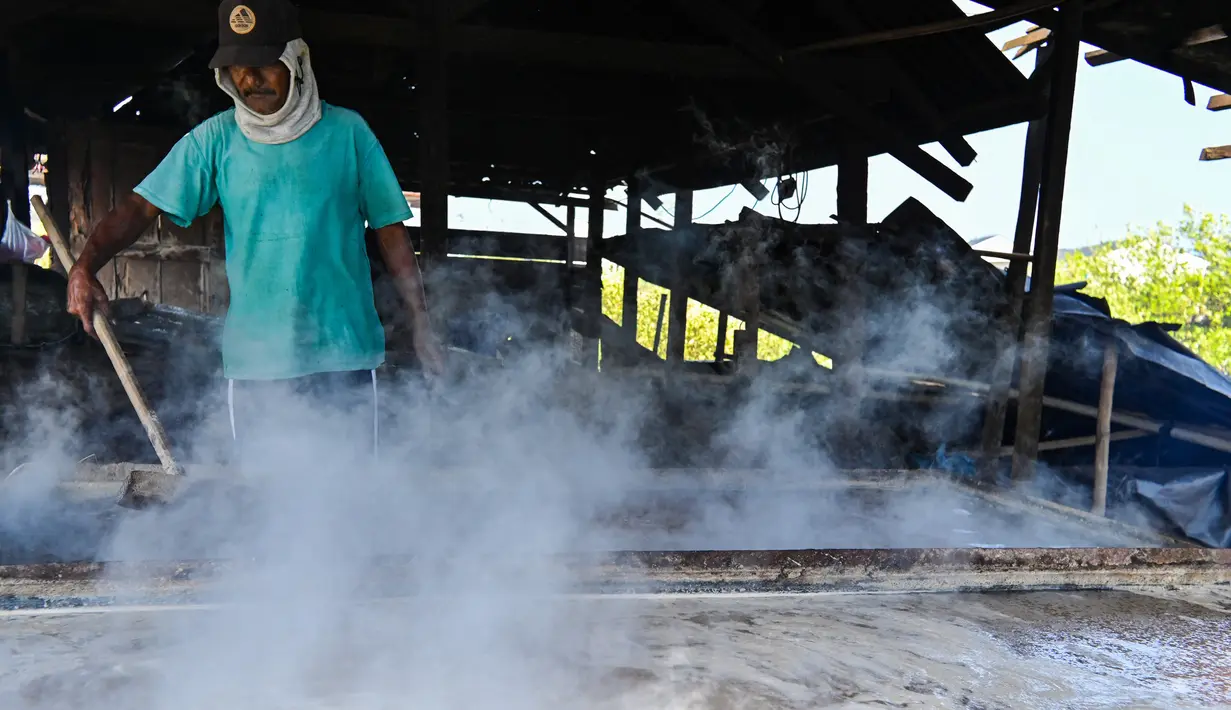 Seorang petani mengolah garam dengan cara tradisional di sebuah tambak di Lamnga, pinggiran Banda Aceh, Aceh, Selasa (7/3/2023). Petani di Aceh masih mengandalkan pola produksi tradisional, yakni sistem rebus. (CHAIDEER MAHYUDDIN/AFP)