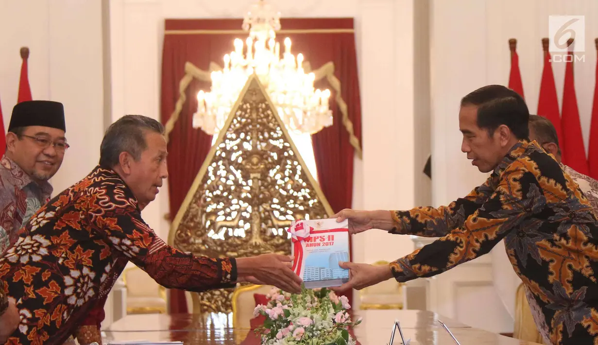 Presiden Joko Widodo (Jokowi) menerima Laporan Ikhtisar Hasil Pemeriksaan Semester (IHPS) II Tahun 2017 yang diberikan Ketua Badan Pemeriksa Keuangan (BPK) Moermahadi Soerja Djanegara di Istana Merdeka, Jakarta, Kamis (5/4). (Liputan6.com/Angga Yuniar)
