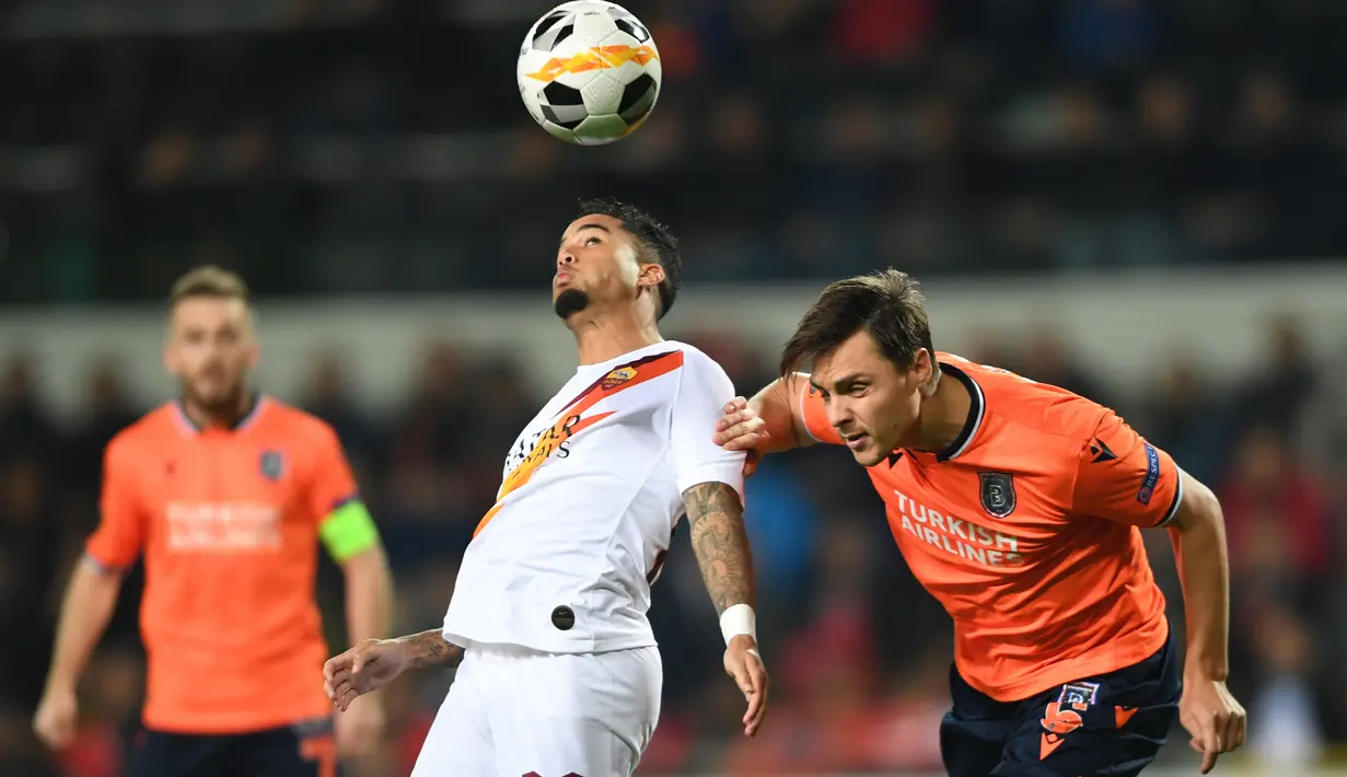 Gelandang AS Roma, Justin Kluivert (tengah) menyundul bola saat berebut dengan pemain Istanbul Basaksehir, Alexandru Epureanu pada laga kelima Grup J Liga Europa 2019-2020 di stadion Fatih Terim, Kamis (28/11/2019). AS Roma menang meyakinkan dengan skor 3-0.  (Ozan KOSE / AFP)