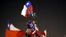 Sejumlah Suporter mengibarkan bendera nasional Chile merayakan kemenangan Chile atas Uruguay di Copa America 2015 di Santiago, Chile, (25/6/2015). Chile melaju ke semifinal usai mengalahkan Uruguay 1-0. (REUTERS/Pablo Sanhueza)