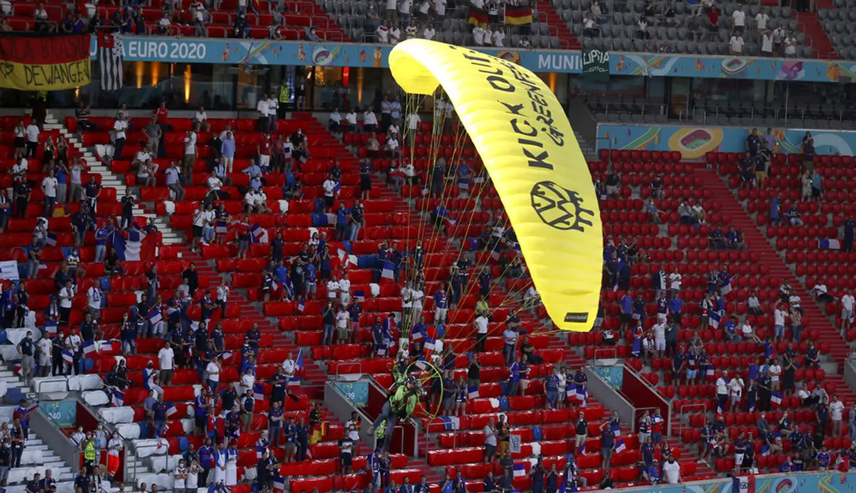 Paraglider Greenpeace mendarat di stadion sebelum pertandingan Grup F Euro 2020 antara Prancis dan Jerman di Allianz Arena, Munich, Jerman, Selasa (15/6/2021). Sang aktivis hampir kehilangan kendali paraglidernya dan hampir menabrak para penonton. (AP Photo/ctivist Alexander Hassenstein, Pool)