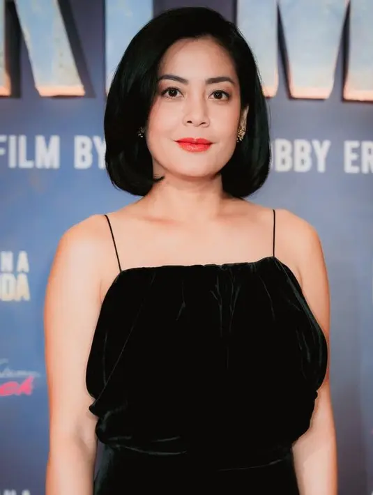 Wajahnya dipoles dengan blush on pink serta lipstik merah glossy. Matanya diperindah dengan blush shimmer kecoklatan. Rambut pendek tertata rapi dengan poni samping memperlihatkan kening. [@armanfebrayan]