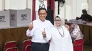 Capres nomor urut 1 Anies Baswedan (kiri) bersama istrinya, Fery Farhati menunjukkan tanda bahwa telah menggunakan hak pilih pada Pemilu 2024, Jakarta, Rabu (14/2/2024). (Liputan6.com/Angga Yuniar)