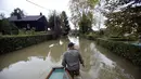 Salah satu pria melintasi jalan di desa Zazina, Kroasia, yang terendam air akibat hujan deras yang turun sejak Rabu lalu, (15/9/2014). (REUTERS/Antonio Bronic)